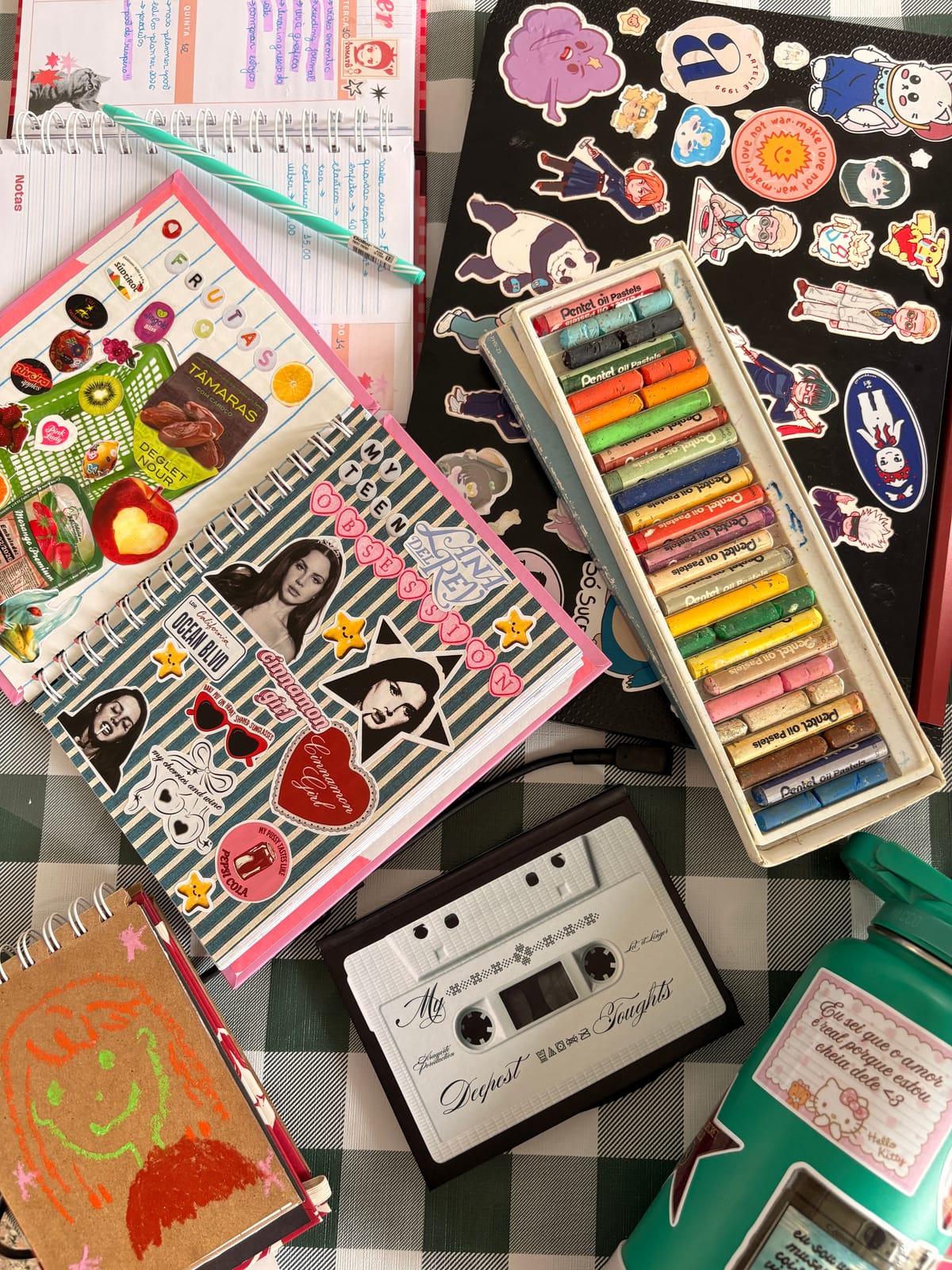 A sticker-covered scrapbook page with oil pastels and embellishments