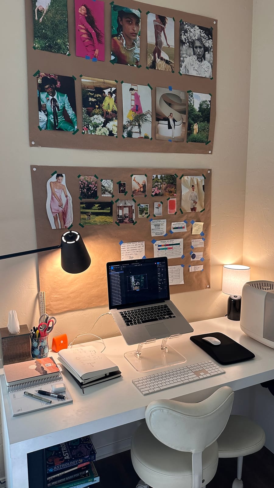 Two kraft-paper vision boards above a desk with a laptop and journals