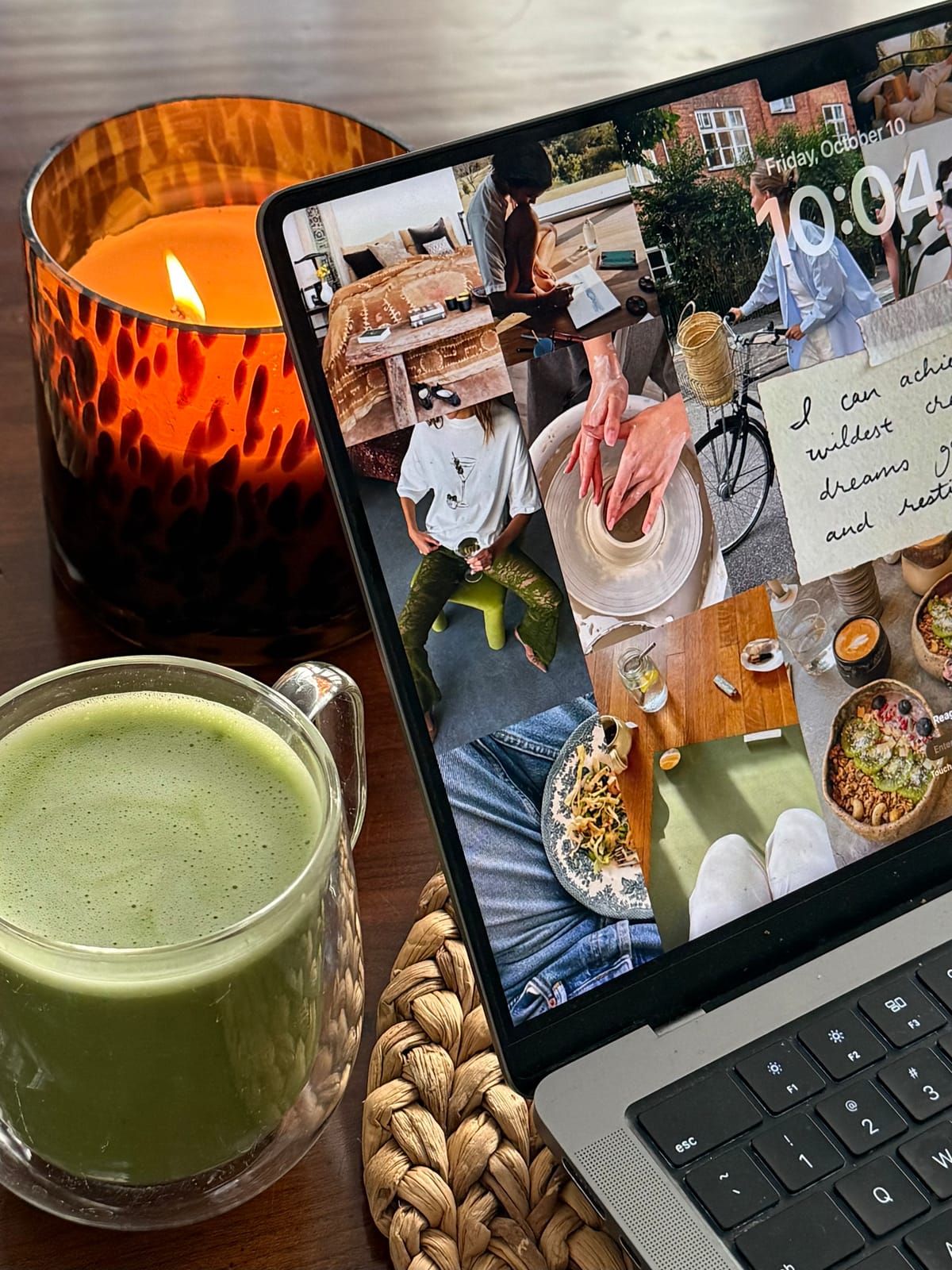 A digital vision board shown on a laptop lock screen beside a matcha latte