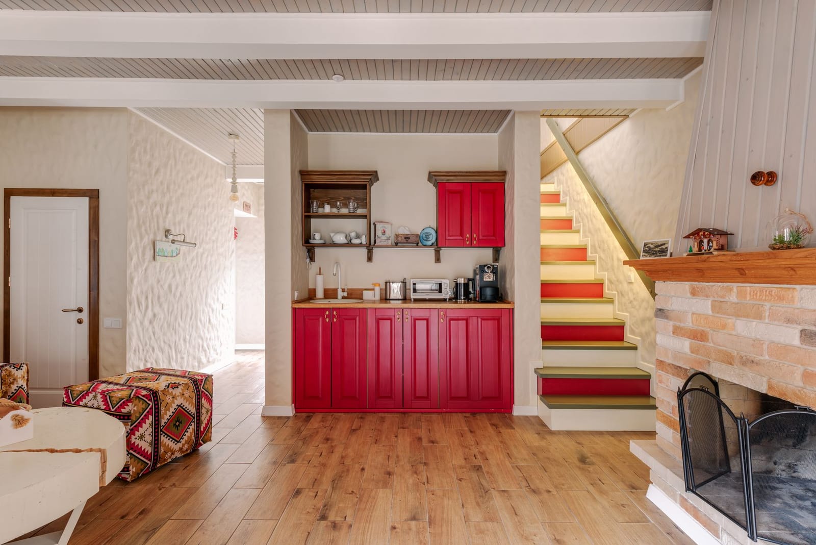 A warm modern kitchen with wood floors, neutral cabinets, and a dining nook