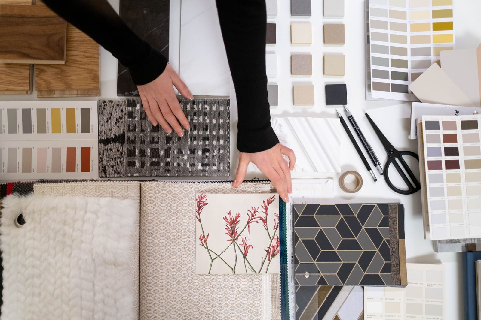 An interior design mood board being arranged from fabric, colour, and material samples